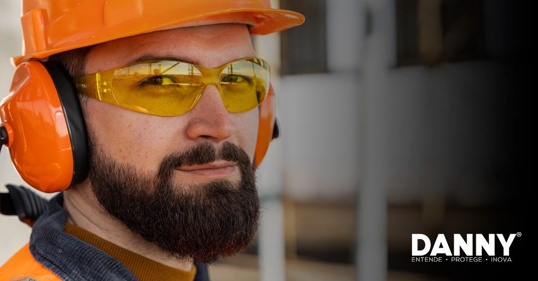 Operário usando óculos, capacete e protetor auricular